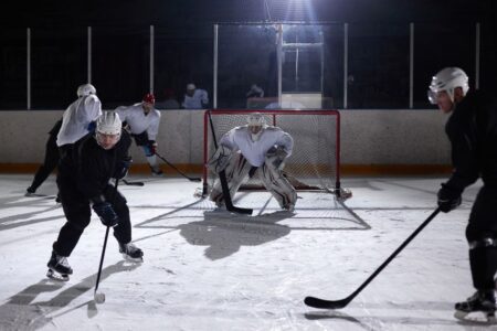 A dynamic moment captured during an ice hockey practice game in an indoor rink.