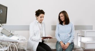 A pregnant woman consulting with a gynecologist in a medical facility.
