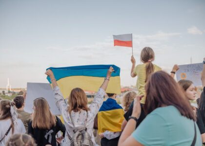 A vibrant demonstration in Szczecin, Poland featuring crowds waving Polish and Ukrainian flags in unity.