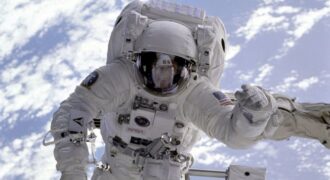Astronaut conducting a spacewalk with Earth in the background, showcasing outer space exploration.