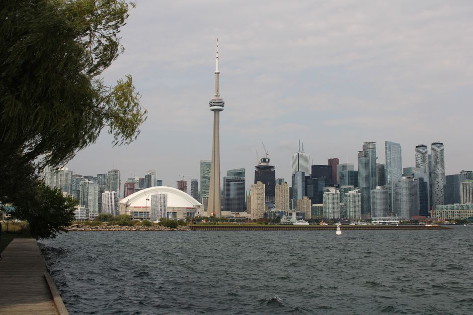Capture of Toronto's iconic skyline featuring the CN Tower and waterfront on a calm day.