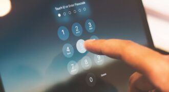 Close-up of a finger entering a passcode on a smartphone security screen.