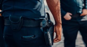 Close-up of a police officer's firearm securely holstered at the waist, conveying professionalism and readiness.