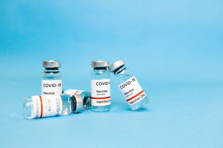 Close-up of COVID-19 vaccine vials against a blue background, symbolizing hope and recovery.
