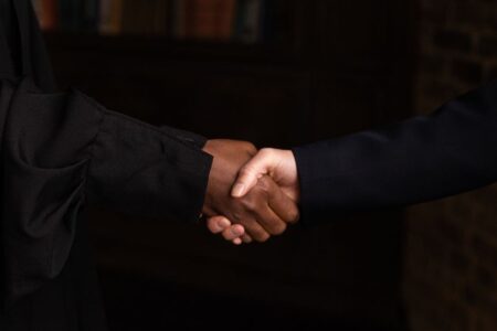 Close-up of diverse individuals shaking hands, symbolizing business agreement.