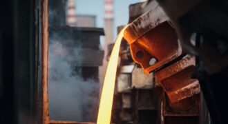 Close-up of molten metal pouring in a foundry, showcasing industrial processes.