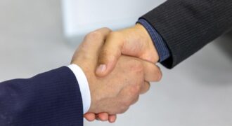 Close-up of two businessmen shaking hands, symbolizing agreement and partnership.