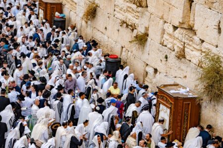 Crowds of people in prayer at the Western Wall, Jerusalem, during a religious event.