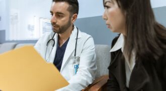 Doctor discusses health records with a patient in a clinical setting.