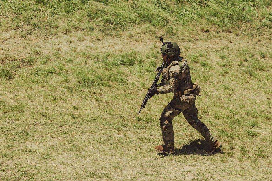 Military soldier in tactical gear running during training exercise at Campo de Mayo, Argentina.