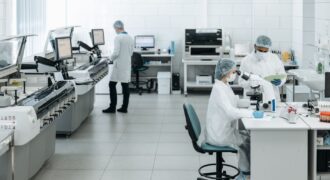 Researchers in lab coats performing experiments with advanced equipment in a laboratory.