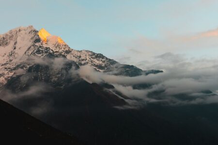 Stunning view of the Himalayan mountains in Nepal during sunrise, with cloud cover adding drama.