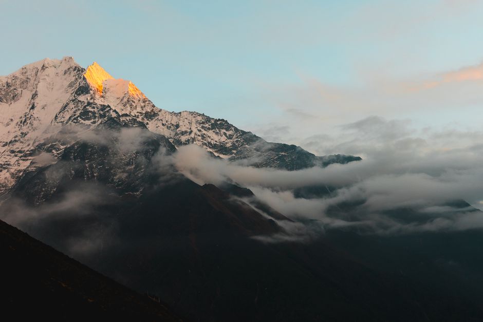 Stunning view of the Himalayan mountains in Nepal during sunrise, with cloud cover adding drama.