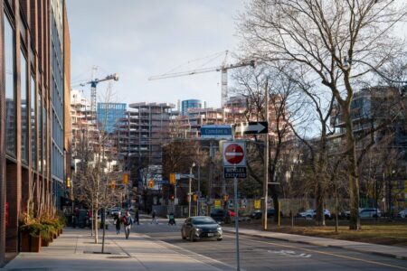 Urban construction site in downtown Toronto with cranes and modern architecture.