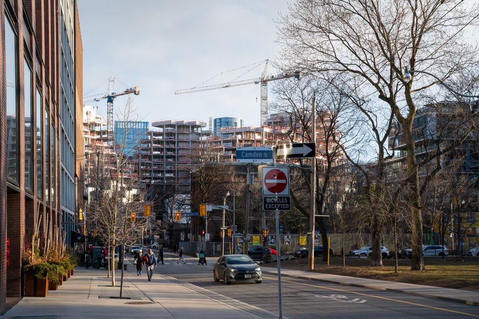 Urban construction site in downtown Toronto with cranes and modern architecture.